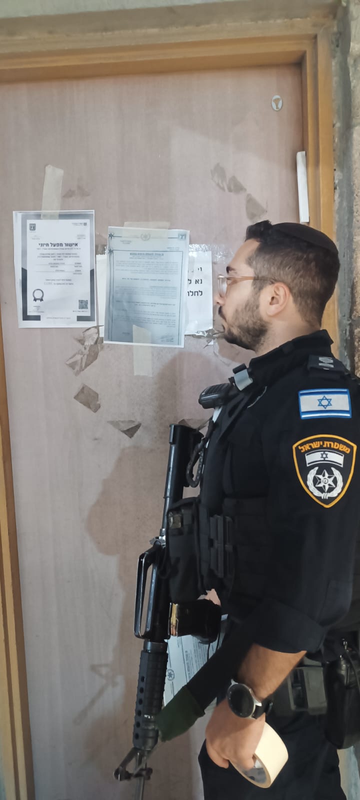שוטר מדביק את צו הסגירה על בית העסק, צילום: דוברות משטרת ישראל